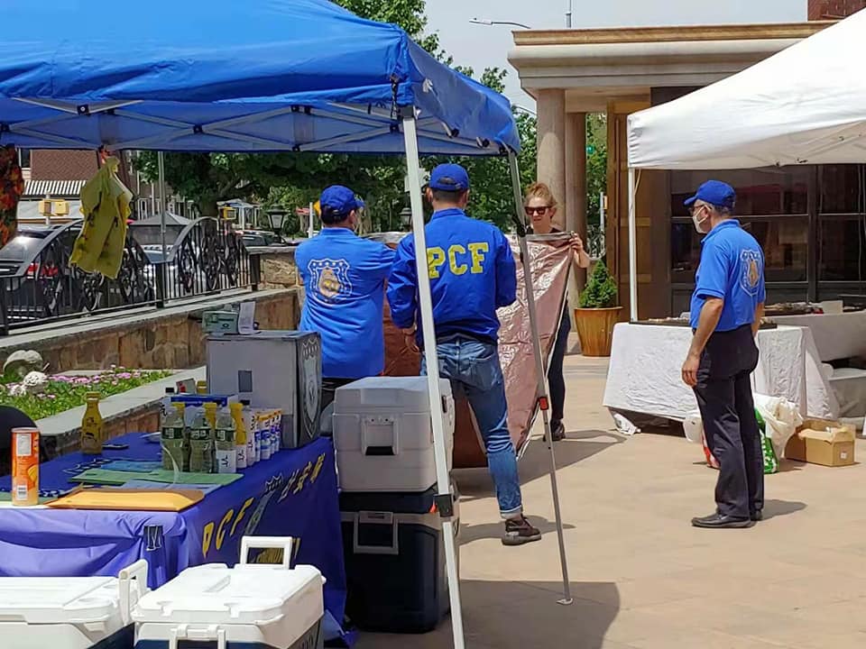 PCF volunteers setting up community booth with supplies for neighborhood outreach