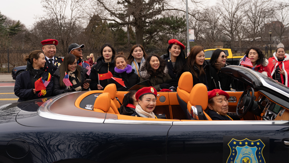 IPVF members participating in parade riding in convertible through Queens