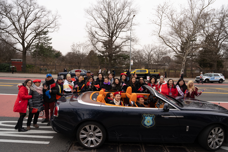 Large group of IPVF members and supporters at Lunar New Year parade with flags